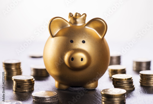 Goldenes Sparschwein mit Krone und Münzen photo