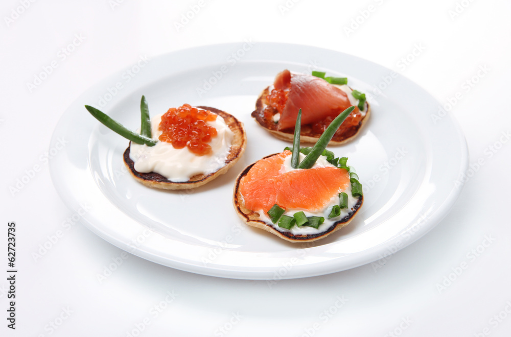 Pancakes with red caviar and salmon,  isolated on white