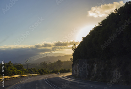 The setting sun around the corner on the road