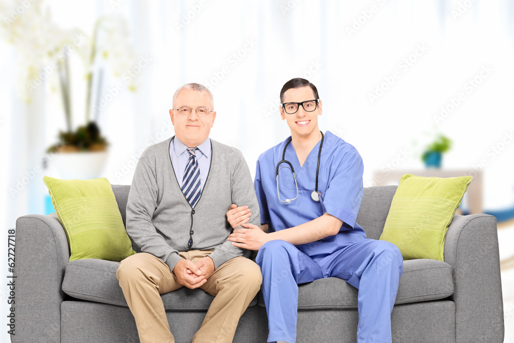 Male doctor and elderly gentleman seated on sofa