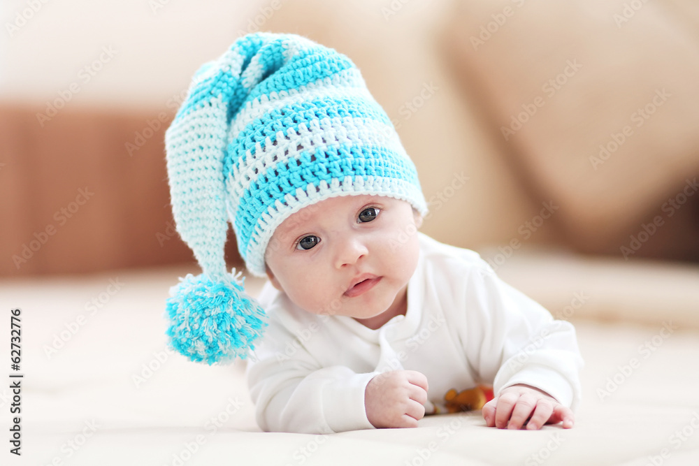 little child lying in the white-blue knitted cap. little child lying in the white-blue knitted cap.