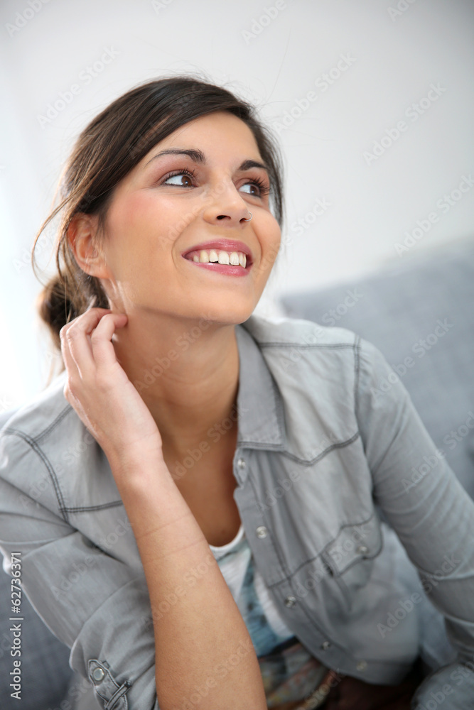 Attractive young woman sitting in sofa Attractive young woman sitting in sofa