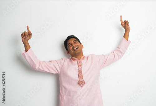 young indian male in traditional cloths celebrating bhangra photo