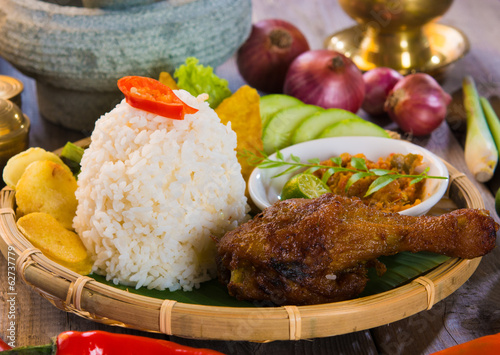 indonesian fried chicken rice on traditional background photo