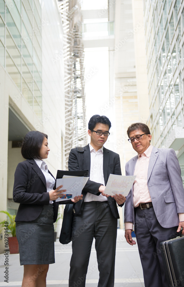 asian business team reporting to senior ceo with office backgrou asian business team reporting to senior ceo with office backgrou