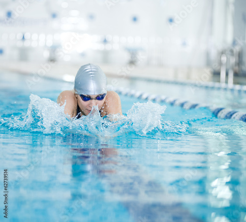 Young girl in goggles swimming breaststroke stroke style