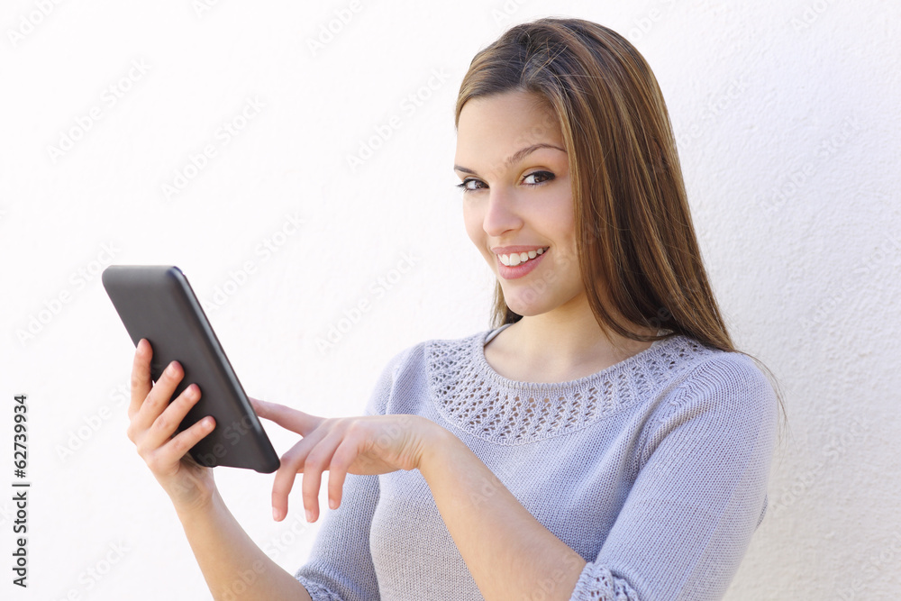 Beautiful woman holding a tablet reader and looking at camera Beautiful woman holding a tablet reader and looking at camera