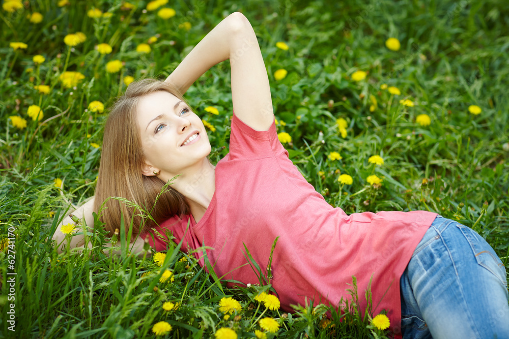 Spring girl lying on the field of dandelions Spring girl lying on the field of dandelions