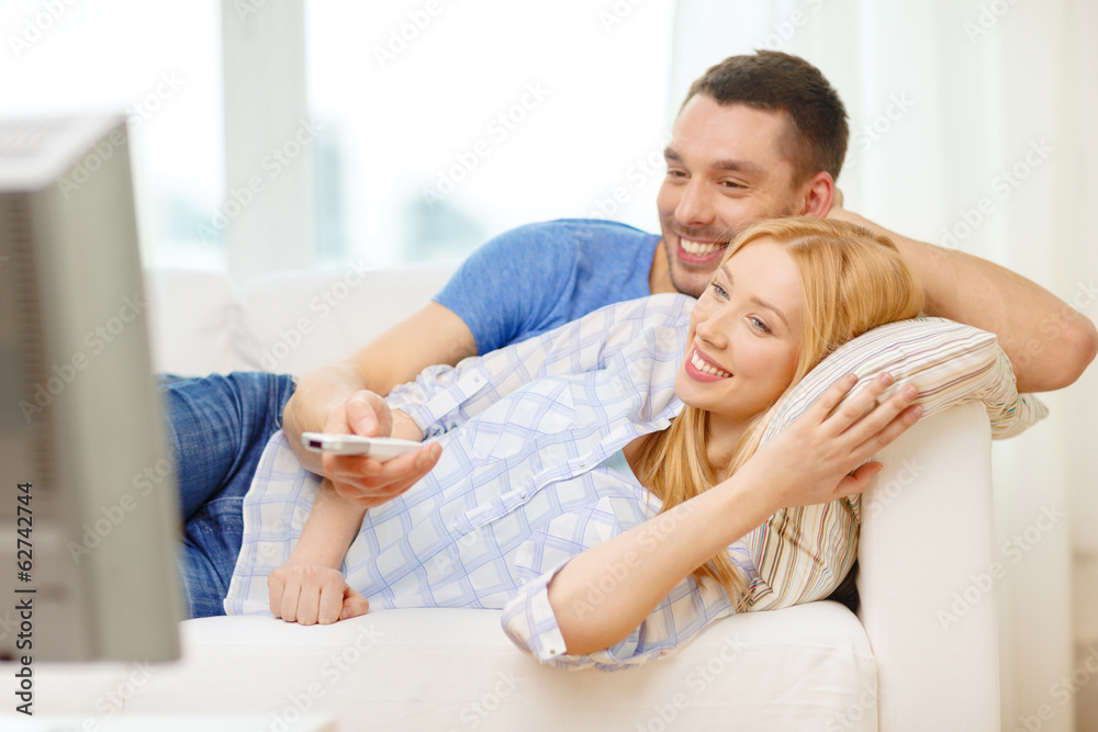 Fototapeta premium smiling couple watching movie at home