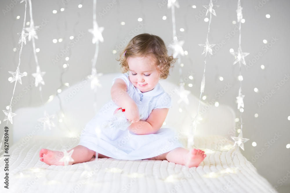 Adorable toddler girl with curly hair wearing a white dress Adorable toddler girl with curly hair wearing a white dress