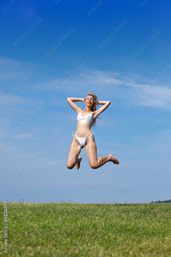 happy woman jumps in summer green field against blue sky.. happy woman jumps in summer green field against blue sky..