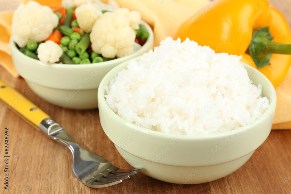 Cooked rice with vegetables on wooden table close up Cooked rice with vegetables on wooden table close up