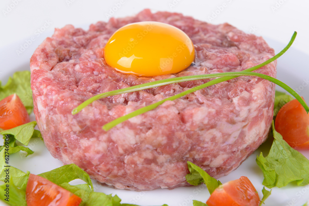 Delicious steak tartare with yolk on plate close-up Delicious steak tartare with yolk on plate close-up