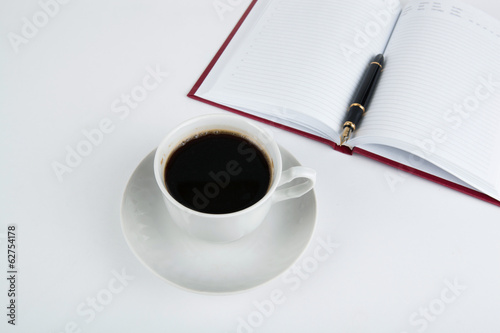 Cup of coffee with diary with fountain pen