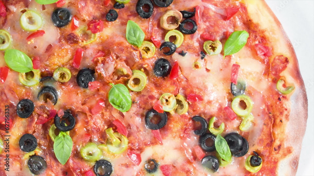 Beautiful multi colored and crispy pizza with basil and cheese Beautiful multi colored and crispy pizza with basil and cheese