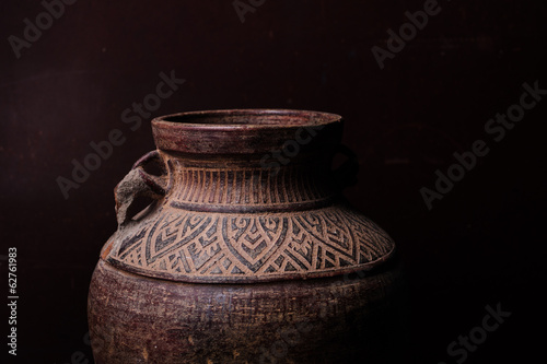 Earthenware jug standing on dark room