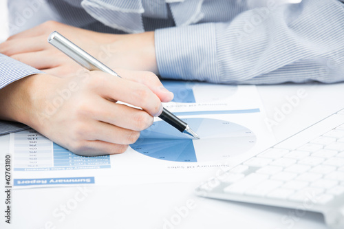 woman hand with pen and business report