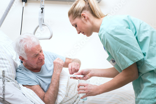 Senior mit Pflegerin im Altenheim Medikamenteneinnahme photo