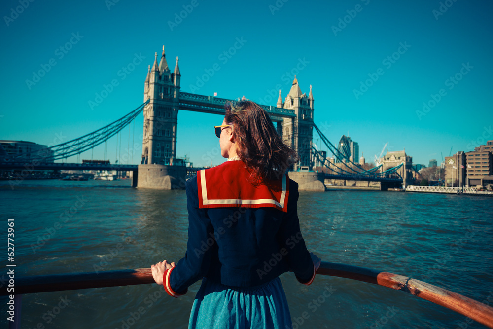 Naklejka premium Young woman on boat looking at Tower Bridge in London