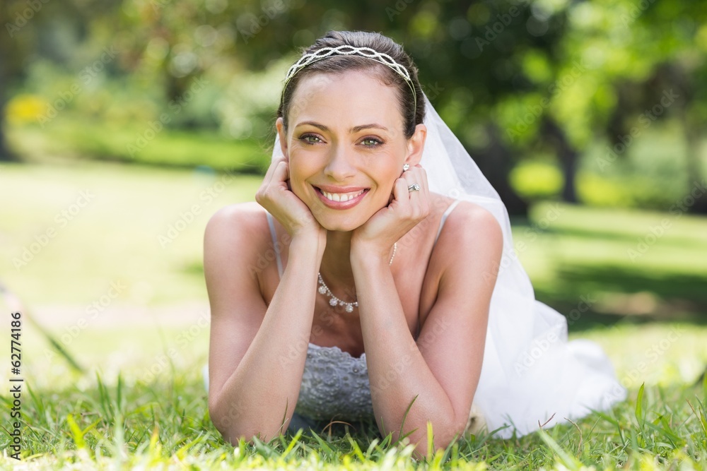 Bride in wedding gown lying on grass Bride in wedding gown lying on grass
