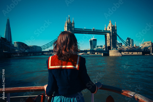 Wall Mural Young woman on boat looking at Tower Bridge in London