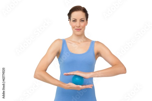 Portrait of a content young woman holding stress ball © WavebreakMediaMicro