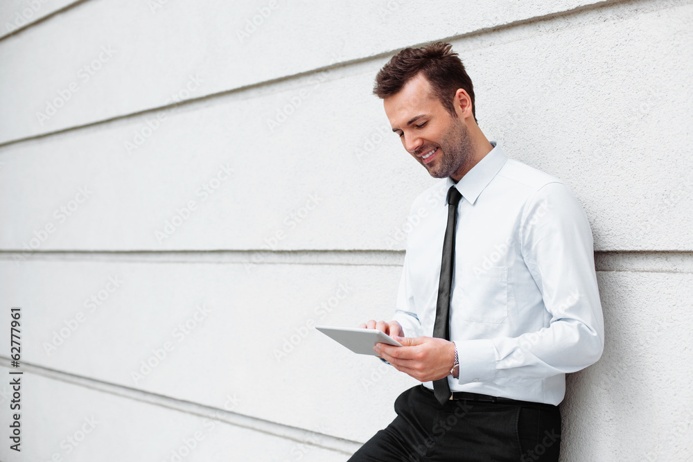 Relaxed businessman standing with digital tablet Relaxed businessman standing with digital tablet