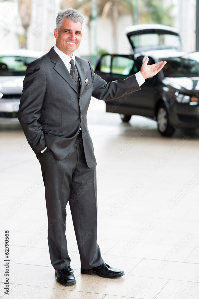 car salesman doing welcoming gesture car salesman doing welcoming gesture
