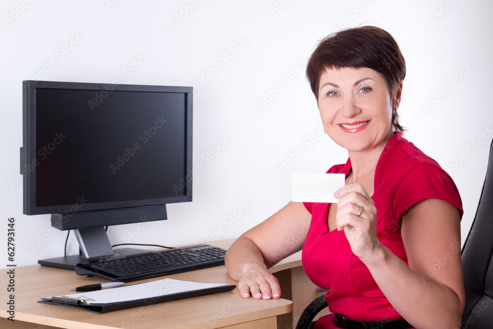 middle aged businesswoman with visiting card sitting in office middle aged businesswoman with visiting card sitting in office