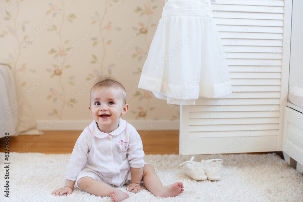 Fototapeta premium portrait of pretty smiling baby girl sitting on the floor
