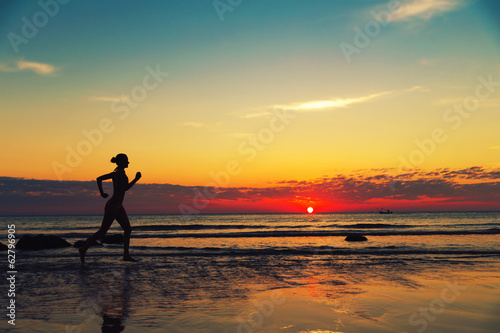 Silhouette of female runing  along the sea coast © Nomad_Soul