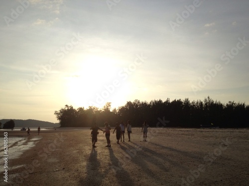 People silhouette at sunset on the beach (face unidentified) © sirins