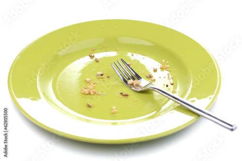 Plate with crumbs and used fork and knife, close-up,