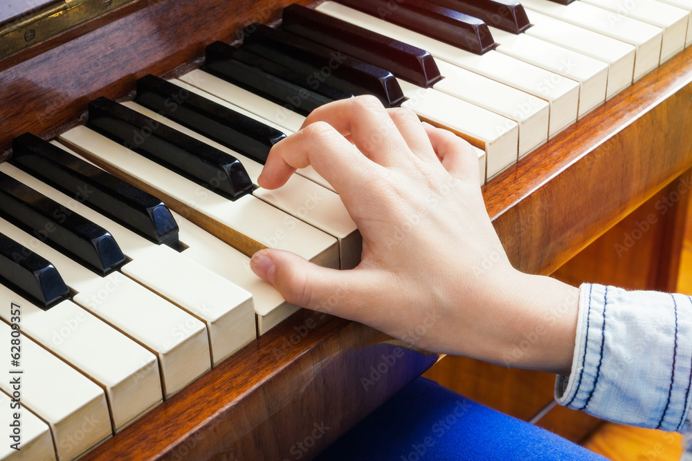 Closeup of child's hand palying piano