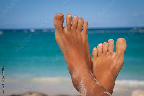 Young woman legs sunbathing on the beach © abelena