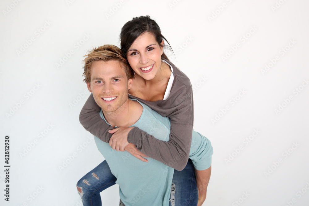 Young man giving piggyback ride to girlfriend Young man giving piggyback ride to girlfriend