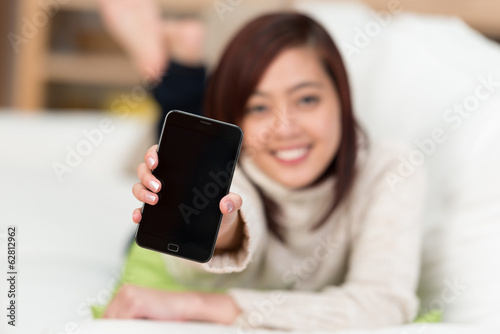junge frau hält smartphone nach vorn