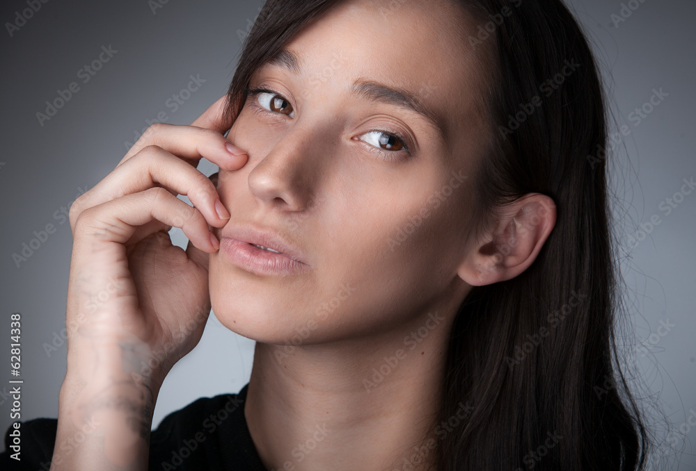 Closeup portrait of slim brunette woman holding hand near mouth Closeup portrait of slim brunette woman holding hand near mouth