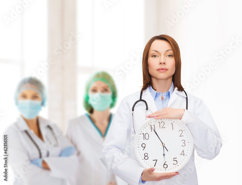 calm female doctor with wall clock photo