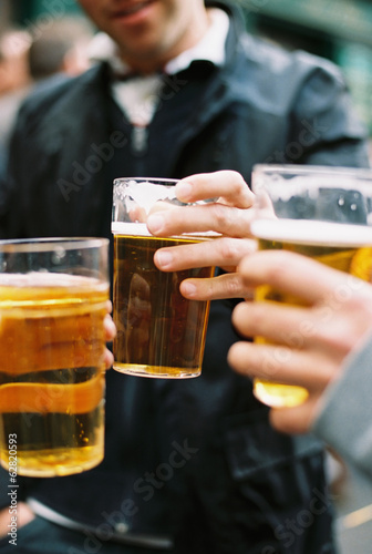 Three people drinking beer. Toasting each other. photo