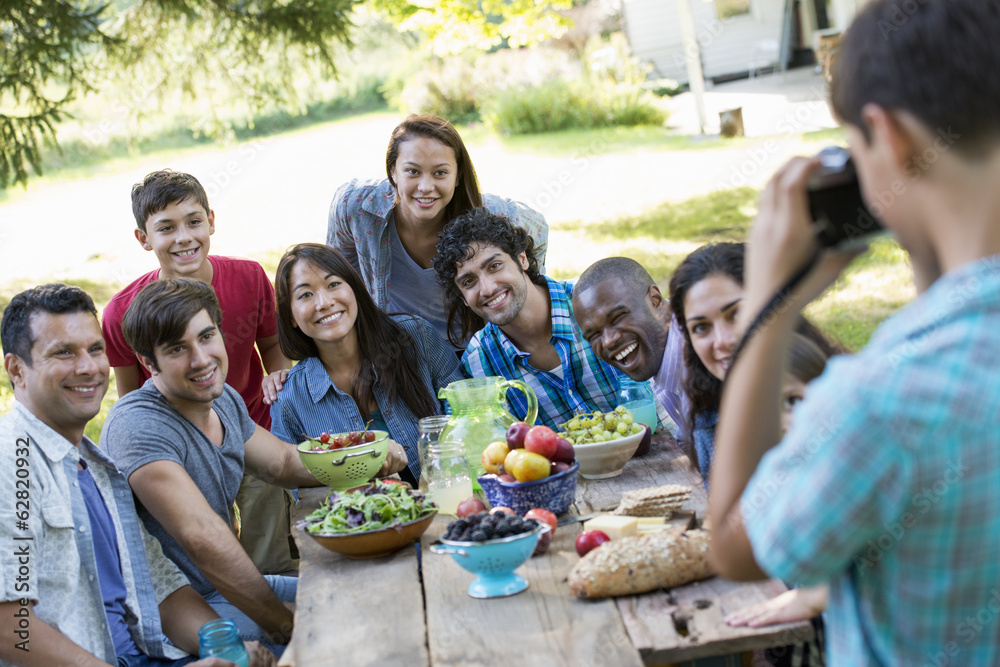 A summer party outdoors. Adults and children posing for a photograph. A summer party outdoors. Adults and children posing for a photograph.