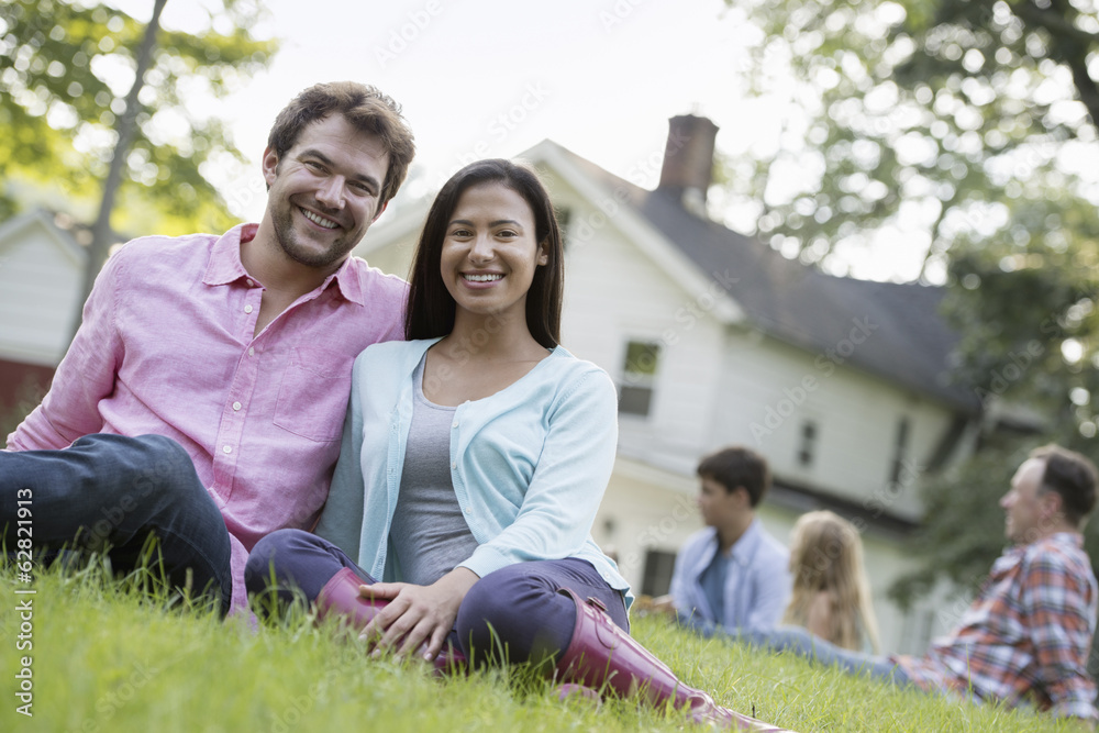 A couple sitting on the grass at a summer party. A couple sitting on the grass at a summer party.