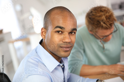 Portrait of young man in business meeting © goodluz