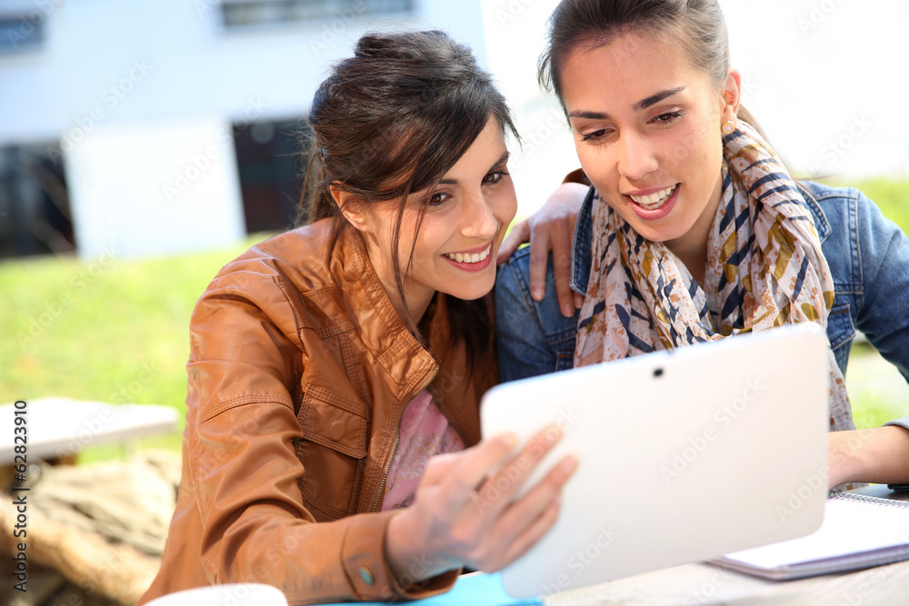 College girls connected on internet with tablet College girls connected on internet with tablet
