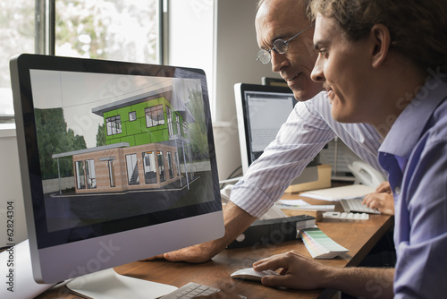 Architects discussing a green construction project, designing and building efficient environmentally friendly buildings. Green architectural practice. 