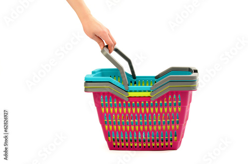 Hand reaching to take a shopping basket from a pile. Isolated.