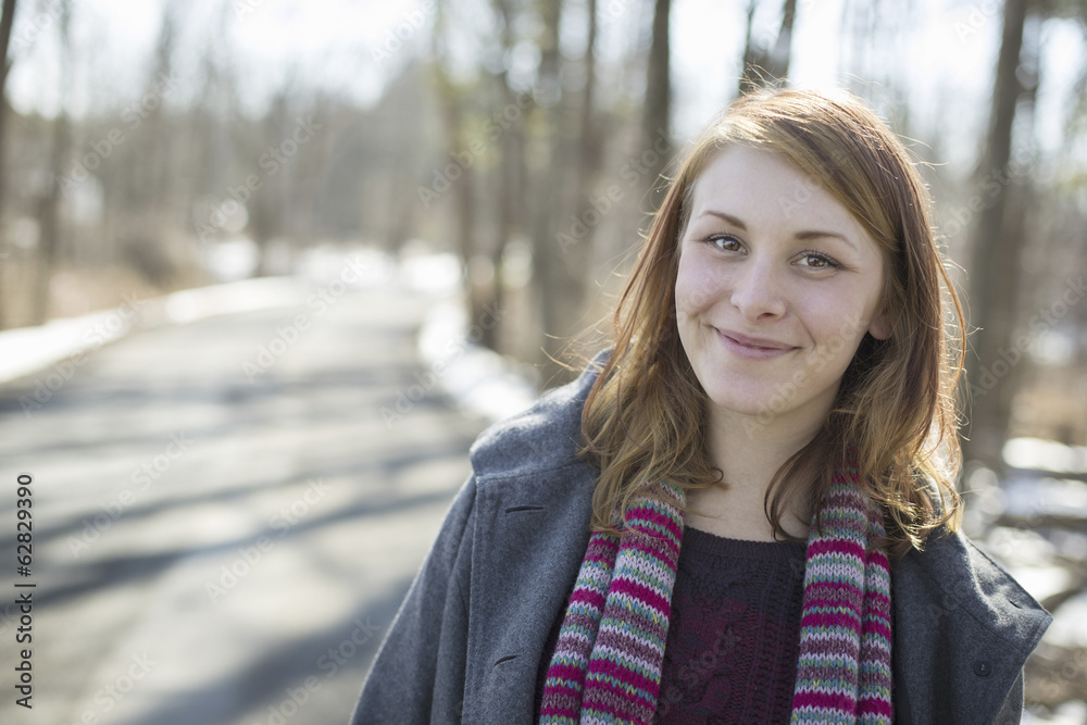 A young woman with a knitted scarf, outdoors on a snowy winter day. A young woman with a knitted scarf, outdoors on a snowy winter day.