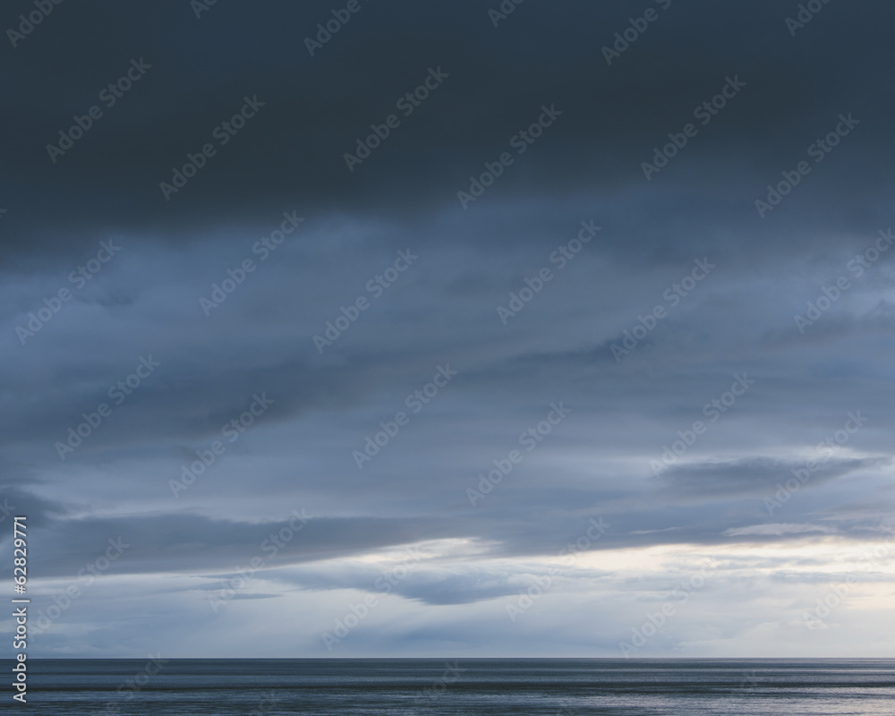 The sea and sky over Puget Sound in Washington, USA. The horizon with light and cloud layers above. Gathering storm clouds. The sea and sky over Puget Sound in Washington, USA. The horizon with light and cloud layers above. Gathering storm clouds.