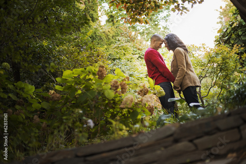 Scenes from urban life in New York City. A park with trees. A man and a woman, a couple holding hands. photo