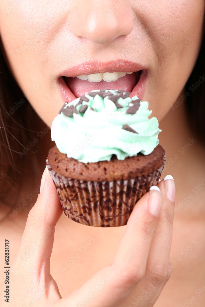 Closeup of woman eating chocolate cupcake